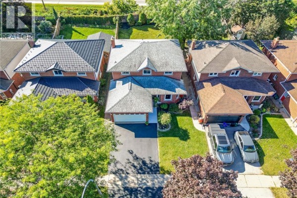 Aerial view looking down on a brick house with a double garage and two cars parked outside. - 31 Princess Boulevard, Grimsby