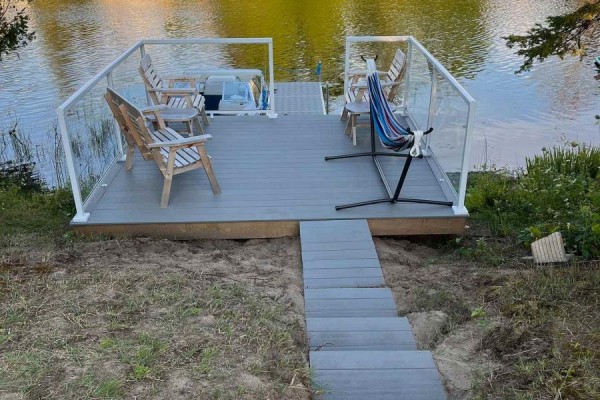 Dock with glass railings, seating, and hammock next to the water. - 31 Sog-je-wa-sa Drive, Native Leased Lands