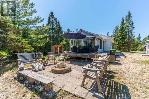Cottage with a large deck and outdoor seating area with a fire pit. - 31 Sog-je-wa-sa Drive, Native Leased Lands