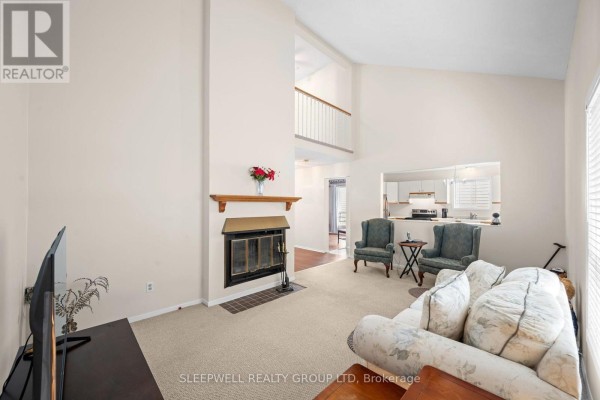 Living room with fireplace, vaulted ceiling, and pass-through to kitchen - 31 Tamblyn Crescent Ottawa
