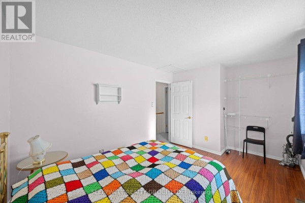 Bedroom with colorful quilt, white shelf, and open door - 31 Tamblyn Crescent Ottawa