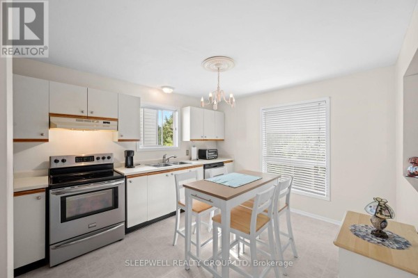 Kitchen with breakfast bar, white cabinets, and stainless steel stove - 31 Tamblyn Crescent Ottawa