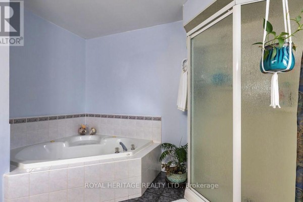 Bedroom with white bedding, armchair, and bedside lamps - 31 Thames Drive N Whitby