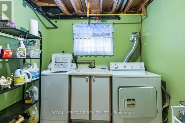 Washer, dryer, and utility sink in a basement laundry room - 31 Thames Drive N Whitby