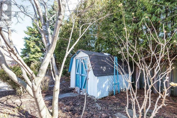 Storage shed in backyard with trees and blue doors - 31 Thames Drive N Whitby