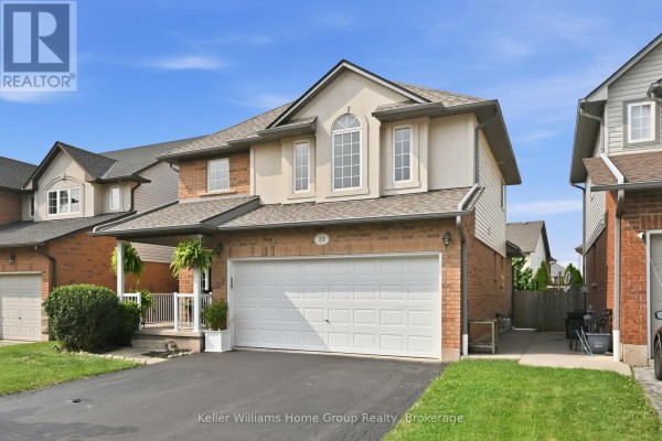 Side exterior view of the house, showing the driveway and a portion of the backyard. - 31 Vinifera Drive, Grimsby