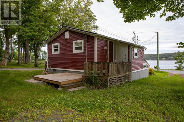 Side view of red house with wood deck and view of the water. - 39 Water Street E, Harbour Grace