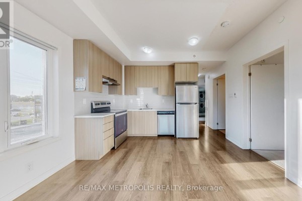 Apartment kitchen and living area with light wood cabinets, stainless steel appliances, and wood-look flooring. - 310 - 20 Orchid Place Drive, Toronto