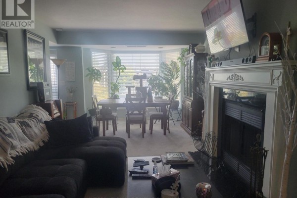 Apartment dining area with a wooden table and chairs in front of bay windows. - 310 - 85 Wellington Street W, Aurora