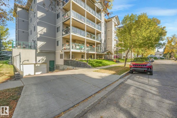 Exterior view of the Summit Peak apartment building with balconies and surrounding trees. - #310 4806 48 Av, Leduc