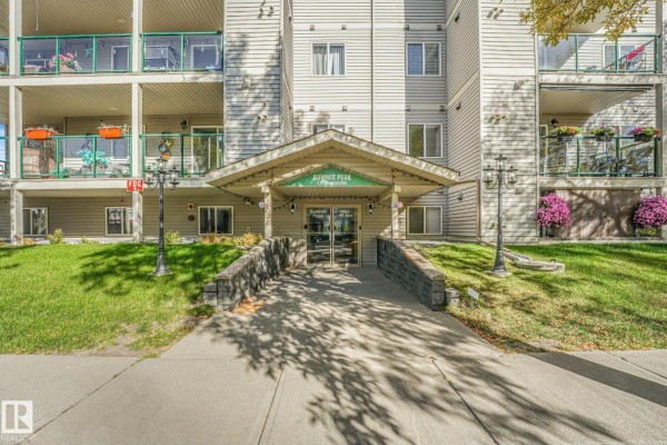 Apartment building entrance with covered walkway, decorative lighting, and stone accents. - #310 4806 48 Av, Leduc
