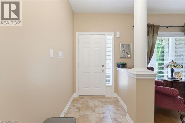 Interior entryway with beige walls, tiled floor, and white front door. - 310 Southbrook Drive Unit# 17, Binbrook