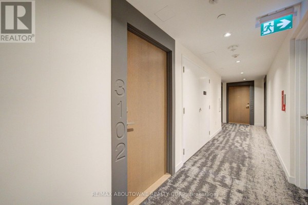 Hallway leading to apartment 3102 with light grey walls and patterned carpet. - 3102 - 20 Richardson Street, Toronto