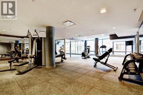 Fitness room with weight machines, free weights, exercise bikes, and rubber tiled flooring. - 3104 1283 Howe Street, Vancouver