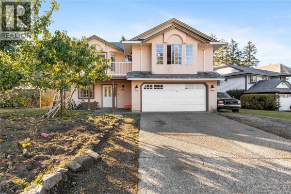 Front exterior view of a two-story house with peach stucco, a white balcony, and a double garage. - 3104 Laurel Grove, Duncan