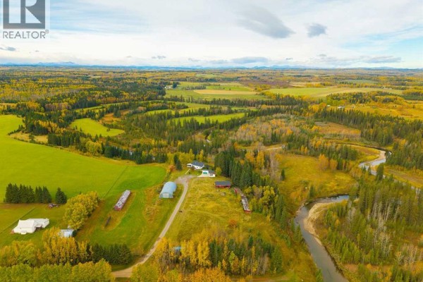 Panoramic aerial view of a rural landscape with rolling hills, fields, forests, a river, and a farmstead. - 31064 Range Road 52, Rural Mountain View County