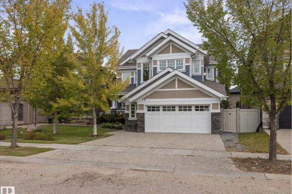 Front exterior of a two-story home with blue siding and stone accents. - 3107 Cameron Heights Wy Nw, Edmonton