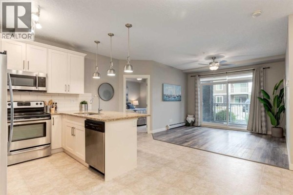Open concept living area with a kitchen island, stainless steel appliances, and living room. - 3109, 522 Cranford Drive Se, Calgary