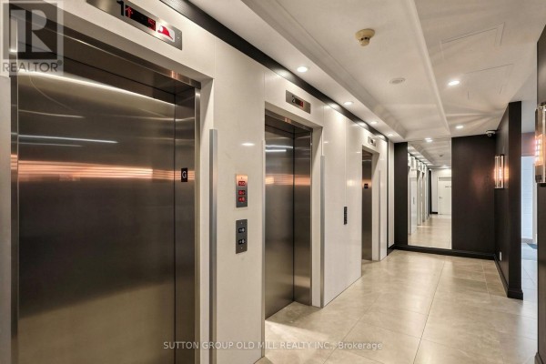 A hallway with multiple polished stainless steel elevators and a marble-tiled floor. - 3109 - 3504 Hurontario Street, Mississauga
