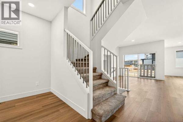 Dining room with a wooden table, grey chairs, and sliding glass doors. - 3109 44 Street S, Lethbridge