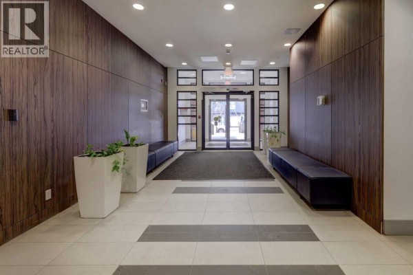 Hallway with wooden paneling, benches, and natural light - 311, 510 Edmonton Trail Ne, Calgary