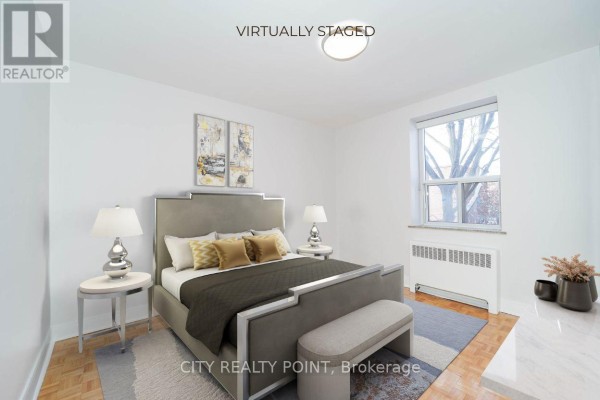 Bedroom featuring a queen-sized bed with grey upholstered headboard and side tables. - 311 - 1291 Bayview Avenue N, Toronto