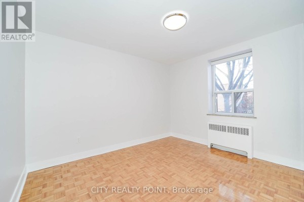 Apartment hallway with a numbered door and white paneled doors, leading to rooms. - 311 - 1291 Bayview Avenue N, Toronto