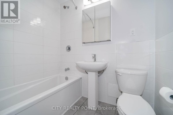 Empty bedroom with white walls, parquet flooring, and a single window with radiator. - 311 - 1291 Bayview Avenue N, Toronto