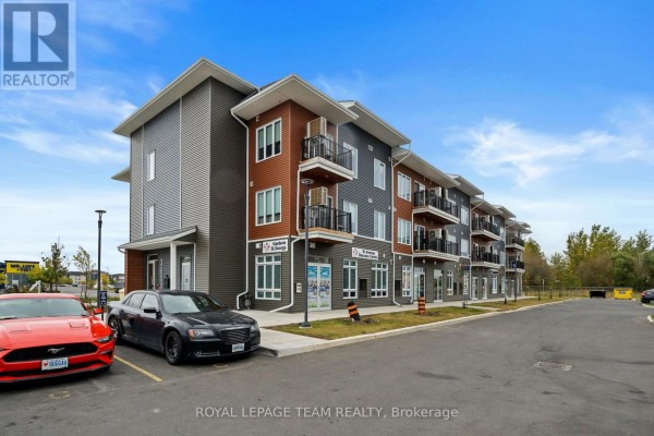 Side view of a contemporary apartment building with commercial units on the ground floor. - 311 - 3600 Brian Coburn Boulevard, Ottawa