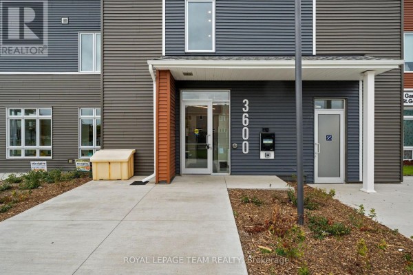 Close-up of the main entrance at 3600 Brian Coburn Boulevard with glass doors and signage. - 311 - 3600 Brian Coburn Boulevard, Ottawa