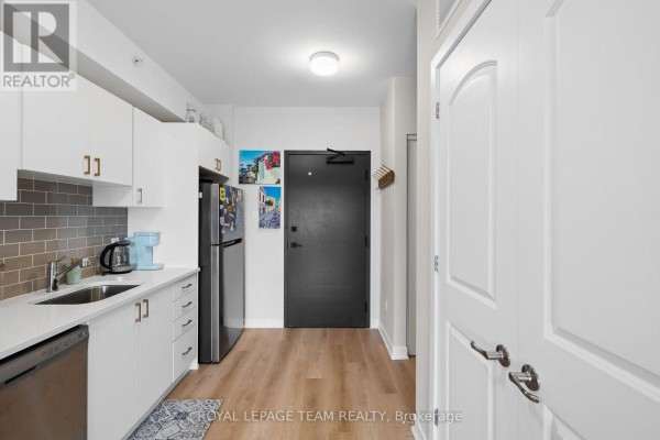 Interior view of a modern kitchen with white cabinets, stainless steel appliances, and wood flooring. - 311 - 3600 Brian Coburn Boulevard, Ottawa