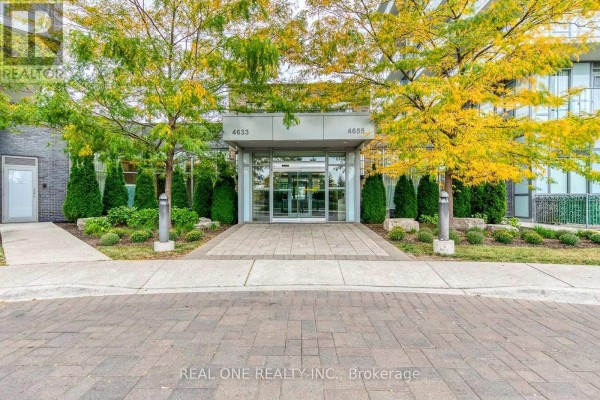 Entrance to the condominium building at 4633 Glen Erin Drive with glass doors and yellow trees. - 311 - 4633 Glen Erin Drive, Mississauga