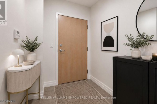 Apartment hallway entrance with a light wood door, modern art, and console table. - 311 - 8 Scollard Street, Toronto