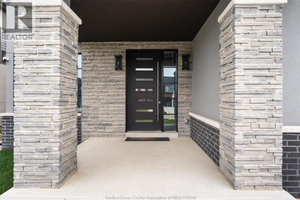 Close-up of the front entrance porch with stone pillars and a modern front door. - 311 Benson Court, Amherstburg