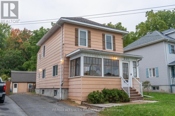 Exterior of a two-story beige house with a screened-in porch at 311 Fourth Street West. - 311 Fourth Street W, Cornwall