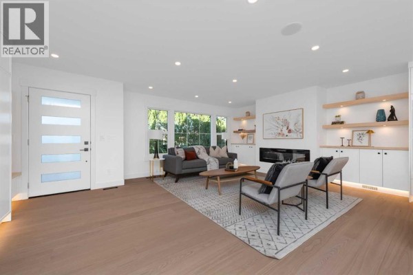 Living room with beige sofas, brick fireplace, and large windows providing natural light. - 311 Parkglen Crescent Se, Calgary