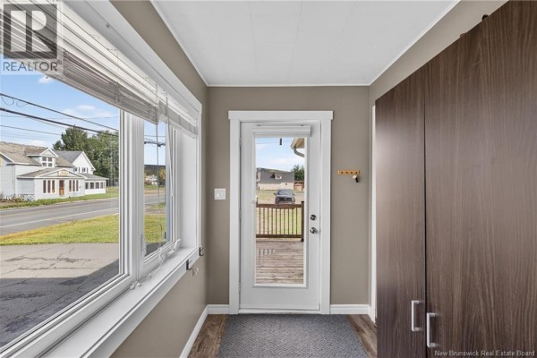 View from inside looking out a large window onto a street with houses and trees. - 311 Principale Street, Eel River Crossing