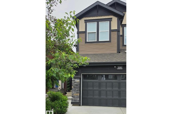 Aerial view of the backyard of houses with tan and red siding, showing wooden fences and yards. - 3114 Chokecherry Bend Sw, Edmonton