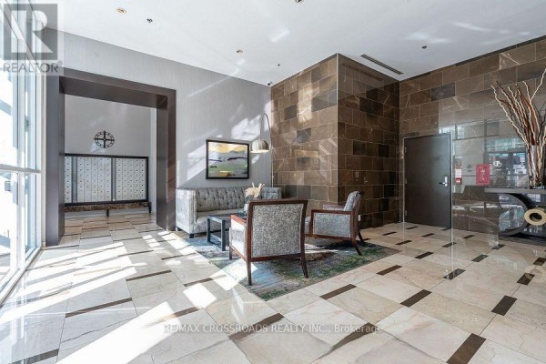 Apartment building lobby with polished stone floors, seating area, and decorative elements. - 312 - 212 Eglinton Avenue E, Toronto