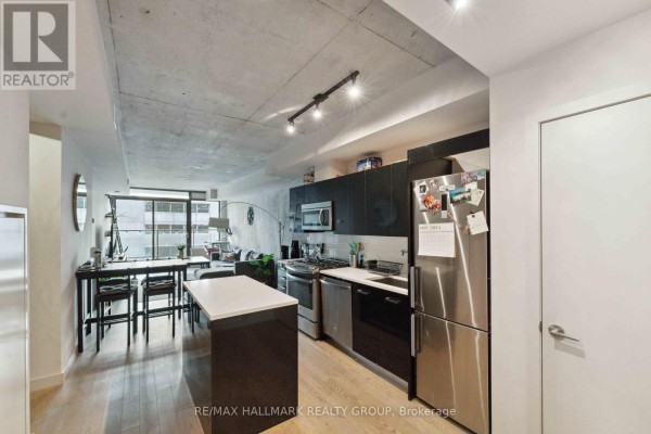 View of an open concept apartment showing the kitchen, dining area, and living space. - 312 - 224 Lyon Street N, Ottawa