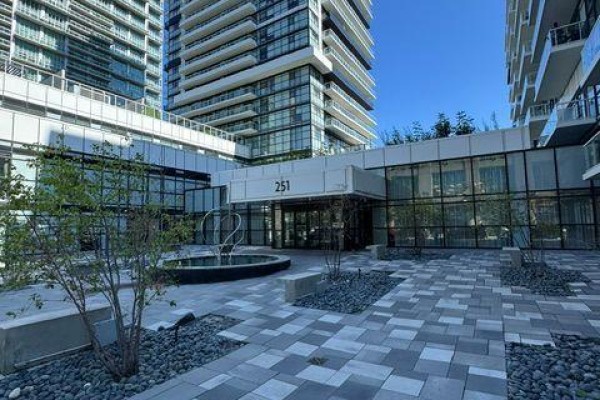 View of distant condo buildings over trees and greenery. - 312 - 251 Manitoba Street, Toronto