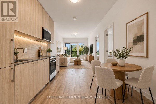 Open concept living area with kitchen, dining table, and living room. - 312 - 7437 Kingston Road, Toronto