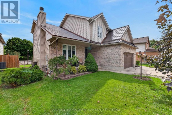 Side view of a two-story beige brick house with beige siding and a metal roof. - 312 Beech Street, Lucan Biddulph