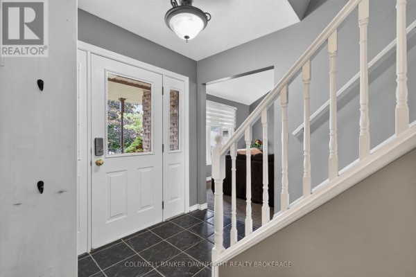 Interior front entryway with grey walls, white trim, and a staircase leading upstairs. - 312 Beech Street, Lucan Biddulph