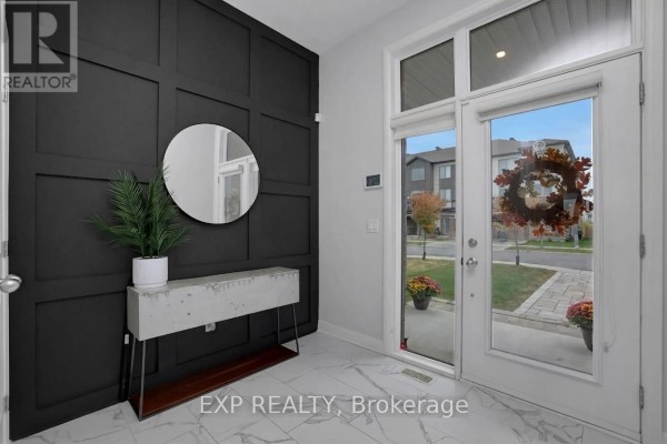 Entranceway interior with white doors and windows, black wall paneling, a console table, and a view of the street outside. - 312 Squadron Crescent, Ottawa