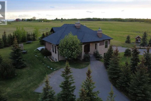 Room with grey walls, large mirror, yoga mat, and electric fireplace. - 31210 Woodland Way, Rural Rocky View County