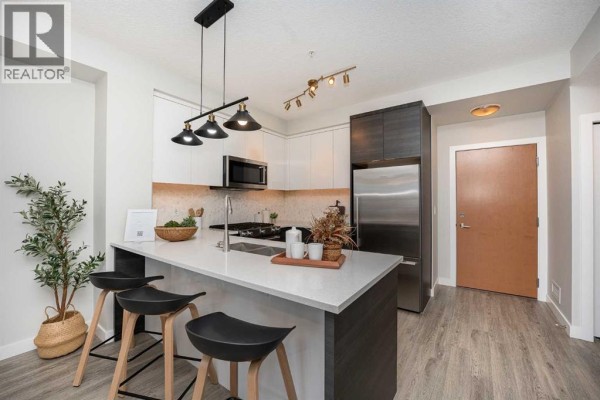 Open concept kitchen and dining area with modern finishes and decorative elements. - 3122, 95 Burma Star Road Sw, Calgary