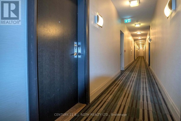 Long hallway with carpeted flooring and wall-mounted lighting - 313 - 15277 Yonge Street S, Aurora