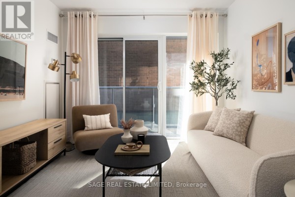 Living room with neutral sofa, armchair, coffee table, and sliding glass doors to balcony. - 313 - 58 Orchard View Boulevard, Toronto