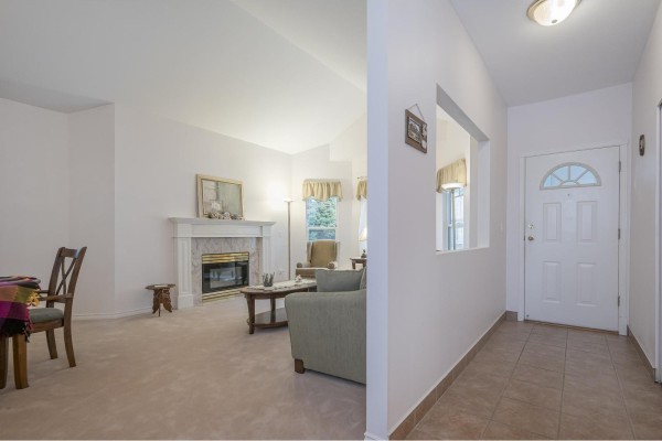 Interior view of living area with fireplace, seating, and entryway - 313 20655 88 Avenue, Langley